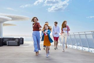Eine Familie genießt einen sonnigen Tag zusammen auf dem Kreuzfahrtdeck mit Meerblick und einer entspannten Atmosphäre | MSC Cruises