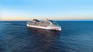 Ein majestätisches Kreuzfahrtschiff segelt auf ruhigem Wasser unter einem klaren blauen Himmel | MSC Cruises